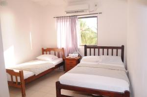 2 camas en una habitación con ventana en Hotel Montecarlo Beach en Tolú