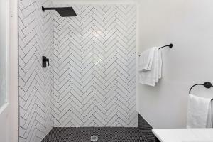 a bathroom with a shower with a chevroniled wall at Blouberg Studio Apartment in Bloubergstrand +38 photos