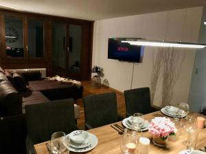 a living room with a table and chairs and a television at Breathtaking Waterfall Apartment nr.2 in Lauterbrunnen