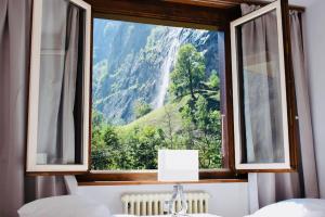 a window with a view of a waterfall at Breathtaking Waterfall Apartment nr.2 in Lauterbrunnen