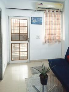 een woonkamer met een bank en een raam bij House 44 1BHK in Greater Noida