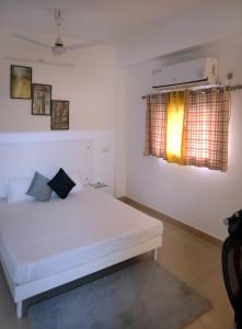 een slaapkamer met een wit bed en een raam bij House 44 1BHK in Greater Noida