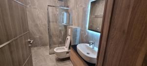 a bathroom with a white toilet and a sink at Hotel Zlatna Žita in Pale