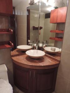 uma casa de banho com 2 lavatórios e um espelho grande em Departamento Para Turistas em Lima