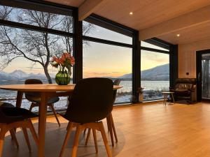 a dining room with a table and large windows at Cabin in Tromsø in Tromsø