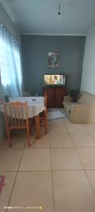 a living room with a table and a couch at Casa Flor De Liz in Alto Paraíso de Goiás