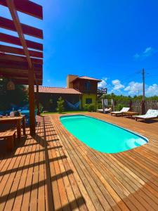 a swimming pool on a wooden deck with a house at TROPICAL HOUSE ATINS in Atins