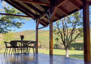 a table and chairs on a porch with a view of a field at Cabana Wonderland in Păuliş