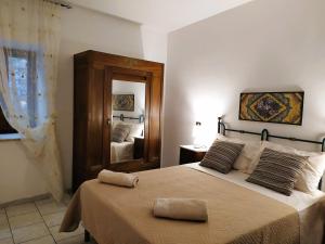 1 dormitorio con 1 cama grande y espejo en Mameli Suite, en Spoleto
