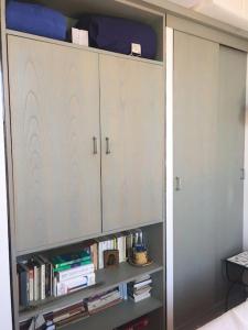 półka na książki w pokoju z białymi szafkami w obiekcie L’Aiguade, appartement d'exception à Cassis w Cassis +15 zdjęć