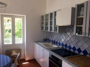 una cucina con mobili bianchi, un lavandino e una finestra di L’Aiguade, appartement d'exception à Cassis a Cassis