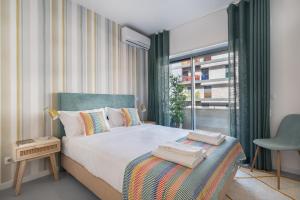 a bedroom with a large bed and a window at Succeed Campo Pequeno Apartments in Lisbon