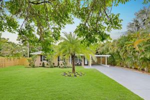 劳德代尔堡Modern 2BRHouse in Wilton Manors with a Heated Pool and KING Bed的房子的院子中的棕榈树