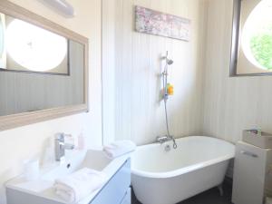 ein weißes Badezimmer mit Badewanne und Waschbecken in der Unterkunft Les Cocons de Stéphanie in Vichy + 41 Fotos