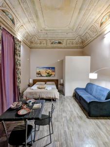 salon z łóżkiem i niebieską kanapą w obiekcie B&B Benincasa w mieście Palermo
