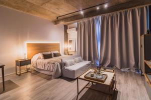 1 dormitorio con cama, sofá y mesa en Amplio Studio con amenities en Pilar, buena ubicación! en Manuel Alberti
