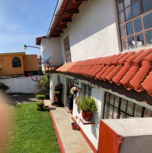 a house with a red tiled roof and a yard at Villa Sofia in Tlatlauquitepec