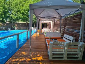 a deck with a tent next to a swimming pool at Alojamiento Quincho Pascual in Las Compuertas