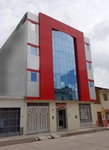 un edificio rojo y blanco con una gran ventana en Hotel ARKONA, en Huancayo