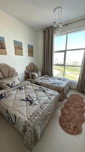 two beds in a room with a window at 2 bedrooms new brand with amazing view in Ajman 