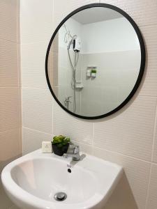 La salle de bains est pourvue d'un lavabo blanc et d'un miroir. dans l'établissement One bedroom Condo Suite in Bacolod City, à Bacolod