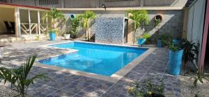 a swimming pool in a patio with plants and a building at Casita de las flores in San José de Ocoa