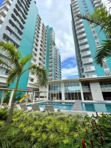 a hotel with a swimming pool in front of tall buildings at One bedroom Condo Suite in Bacolod City in Bacolod