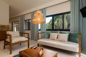 a living room with a couch and a table at Lodoicea Apartments in Bel Ombre