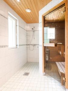 uma casa de banho com um chuveiro e um lavatório. em Kujanpää | Paajoen Vuokramökit em Himos