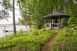 a gazebo sitting on the side of a lake at Kujanpää | Paajoen Vuokramökit in Himos