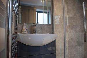 a bathroom with a white sink and a mirror at Silver Forge - Luxury High End Two Bedroom - En Suite - City Centre in Birmingham