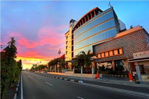 a building on the side of a street with a sunset at Ros-In Hotel in Yogyakarta