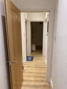 une porte ouverte menant à un couloir menant à une chambre dans l'établissement I&J Suites, à Woolwich