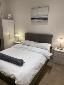 I&J Suites في Woolwich: غرفة نوم بسرير ابيض كبير ومصباحين