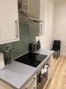 a kitchen with a sink and a stove top oven at I&J Suites in Woolwich