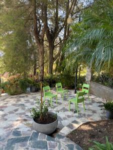 eine Terrasse mit grünen Stühlen und einem Baum in der Unterkunft Villa Paloma/ Home/ Office-Remote Office in Constanza