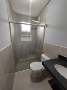 uma casa de banho com um chuveiro, um WC e um lavatório. em FLAT SABIÁ em Uberlândia