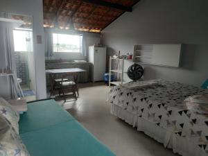 um quarto com uma cama e uma cozinha com uma mesa em VENTO E SAL - Cobertura MAR em Ilhéus