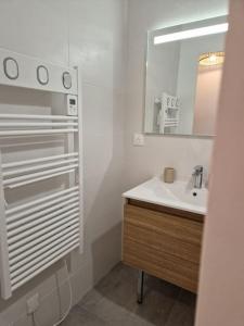 uma casa de banho branca com um lavatório e um espelho em Au coin des châteaux - T3 proche de Chambord em Mer