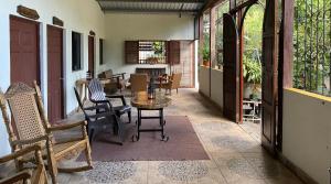 Zimmer mit einem Tisch und Stühlen auf einer Veranda in der Unterkunft Hostal Café El Cedro in Berlín