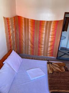 a bed in a room with a colorful wall at Emallayan Hostel in Imsouane