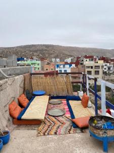 a room with two beds on top of a building at Emallayan Hostel in Imsouane