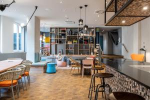 um restaurante com um bar com cadeiras e mesas em Aparthotel Adagio access Hamburg em Hamburgo