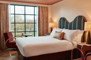 a hotel room with a bed and a large window at The Hoxton, Shepherds Bush in London