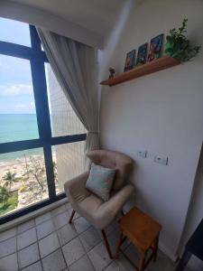 sala de estar con silla y ventana grande en Flat 711 Golden Beach, en Recife