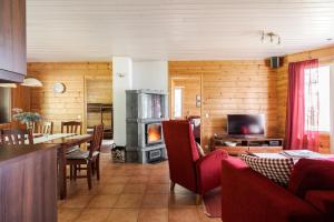 a living room with a table and a fireplace at Suvituuli | Paajoen Vuokramökit in Himos