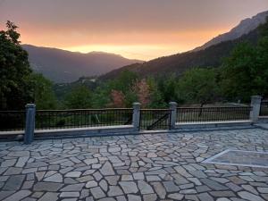 a stone patio with a fence and mountains in the background at Villa Pallas 