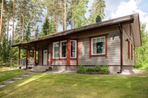 una pequeña casa en el bosque con un patio en Suvituuli | Paajoen Vuokramökit, en Himos