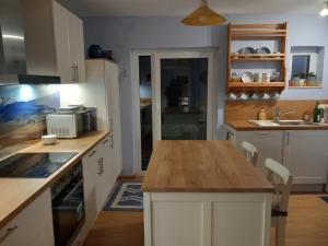 a kitchen with white cabinets and a wooden counter top at Ferienwohnung in Treysa in Schwalmstadt