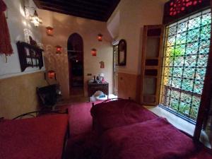 - un salon avec un canapé et une fenêtre dans l'établissement Ryad Nour Al Janoub, à Marrakech